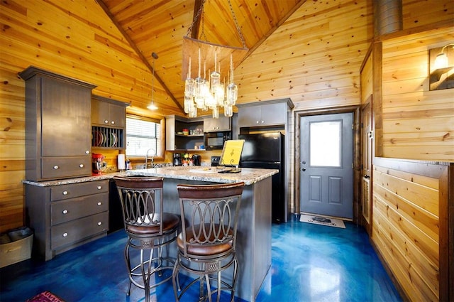 kitchen with a center island, high vaulted ceiling, and black appliances