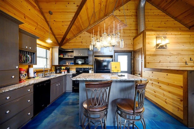 kitchen featuring sink, light stone counters, pendant lighting, a kitchen island, and black appliances