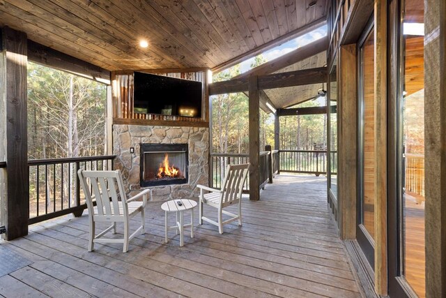 wooden terrace featuring an outdoor stone fireplace