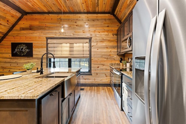 kitchen with appliances with stainless steel finishes, light wood-type flooring, vaulted ceiling, wooden walls, and wooden ceiling