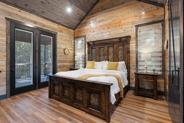 bedroom featuring access to exterior, light hardwood / wood-style flooring, wood walls, and wood ceiling