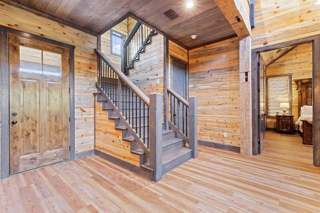 stairs with wood-type flooring, wooden ceiling, and wood walls