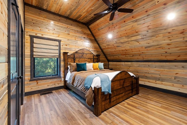 bedroom with vaulted ceiling, ceiling fan, wooden walls, hardwood / wood-style flooring, and wooden ceiling