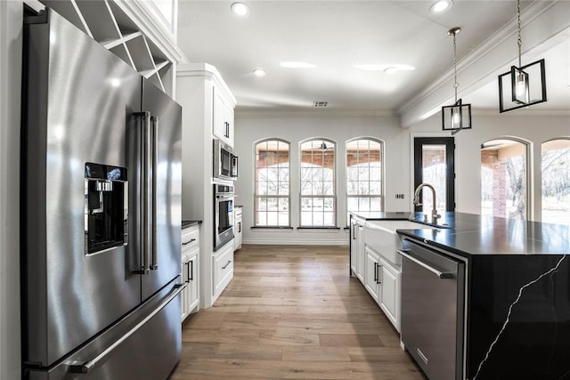 5900 N Choctaw Rd, Choctaw, OK 73020 - kitchen featuring appliances with stainless steel finishes, dark countertops, wood finished floors, crown molding, and white cabinetry