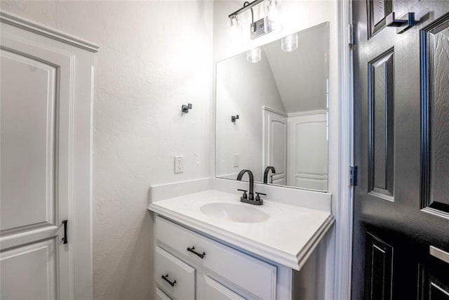 bathroom with vanity and lofted ceiling