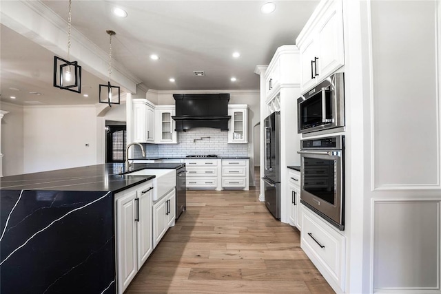 5900 N Choctaw Rd, Choctaw, OK 73020 - kitchen featuring appliances with stainless steel finishes, custom range hood, glass insert cabinets, backsplash, and ornamental molding