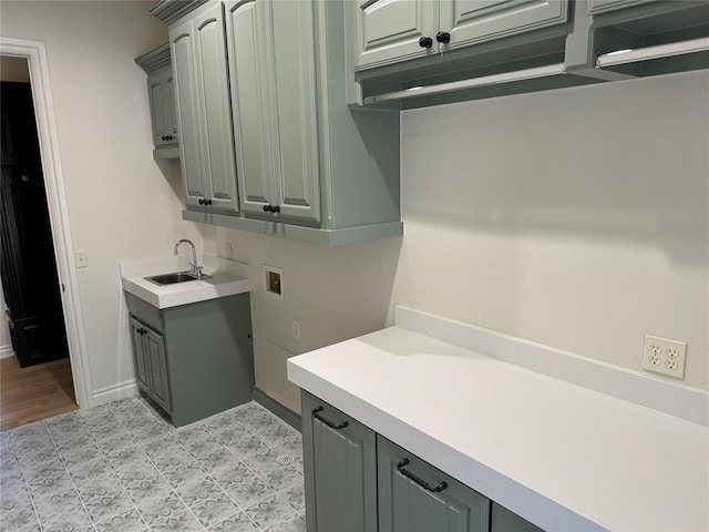 clothes washing area featuring washer hookup, cabinets, and sink