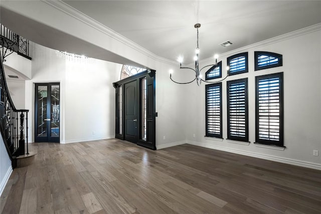 unfurnished dining area with a chandelier, dark wood-type flooring, and ornamental molding