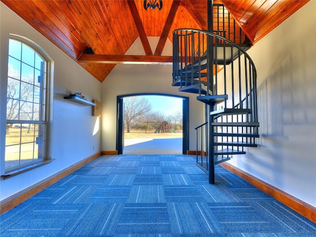 carpeted foyer with lofted ceiling with beams and wood ceiling