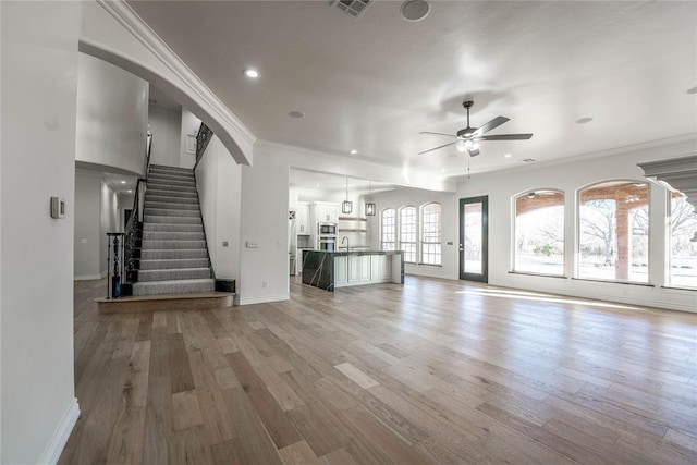 5900 N Choctaw Rd, Choctaw, OK 73020 - unfurnished living room with ceiling fan, light wood finished floors, crown molding, stairway, and recessed lighting
