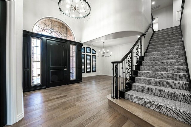 5900 N Choctaw Rd, Choctaw, OK 73020 - foyer with a chandelier, stairway, wood finished floors, a towering ceiling, and healthy amount of natural light