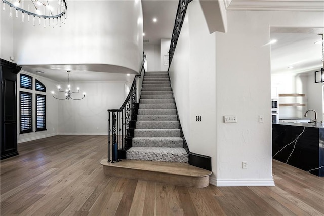 5900 N Choctaw Rd, Choctaw, OK 73020 - staircase featuring a chandelier, wood finished floors, and crown molding