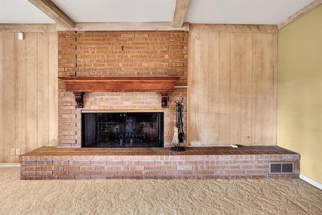 room details with a fireplace, carpet flooring, beamed ceiling, and wood walls