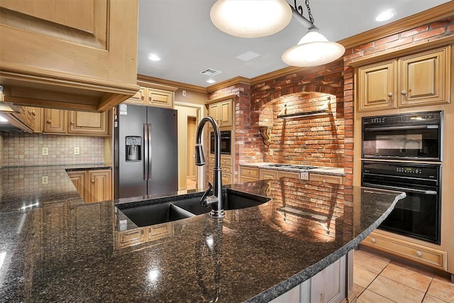 kitchen featuring sink, dark stone countertops, crown molding, pendant lighting, and appliances with stainless steel finishes