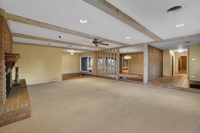 unfurnished living room with light carpet, a fireplace, beamed ceiling, and ceiling fan