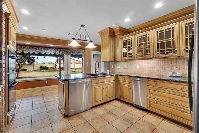 kitchen with sink, hanging light fixtures, kitchen peninsula, light tile patterned floors, and appliances with stainless steel finishes