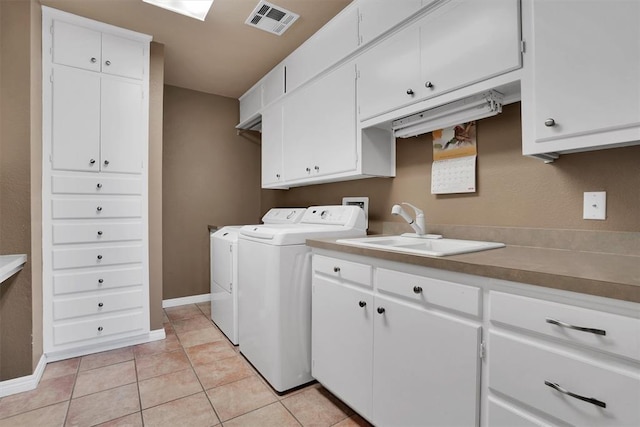 laundry room with washer and clothes dryer, sink, light tile patterned flooring, and cabinets