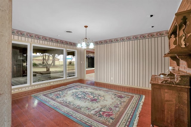 dining room with hardwood / wood-style flooring and a notable chandelier