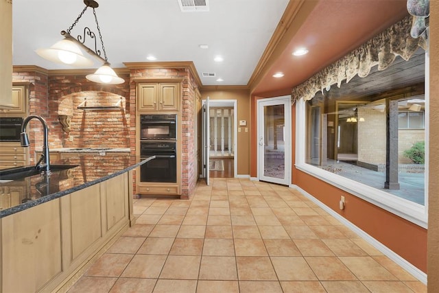 kitchen with crown molding, sink, light tile patterned floors, dark stone countertops, and hanging light fixtures