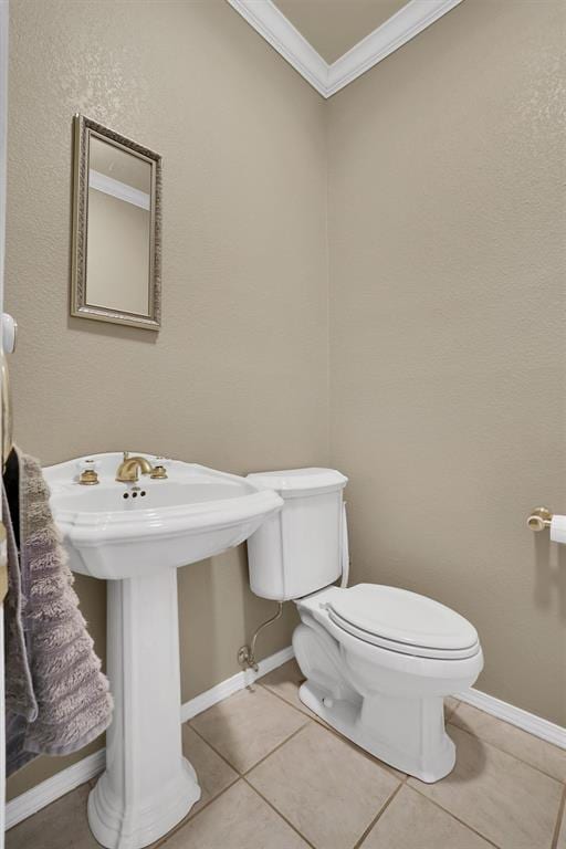 bathroom with tile patterned floors, sink, toilet, and crown molding