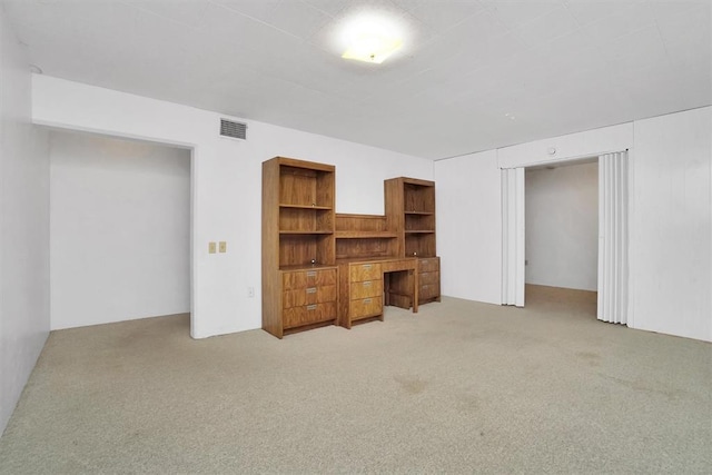 unfurnished living room featuring light carpet