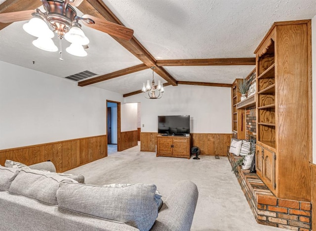 carpeted living room featuring lofted ceiling with beams, a textured ceiling, and ceiling fan with notable chandelier