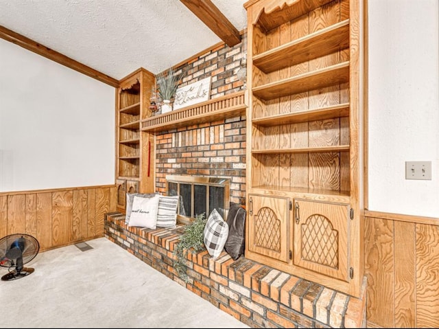 living room with a textured ceiling, light colored carpet, built in features, and wood walls