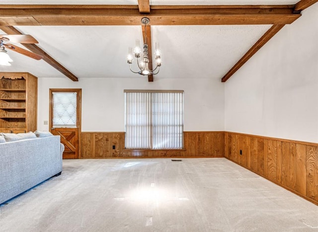 interior space with lofted ceiling with beams, ceiling fan with notable chandelier, and light colored carpet