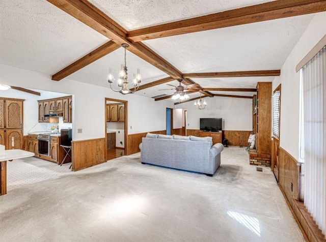 living room featuring wood walls, ceiling fan with notable chandelier, lofted ceiling with beams, and a textured ceiling