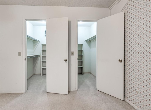 bedroom featuring a walk in closet, a closet, and a textured ceiling