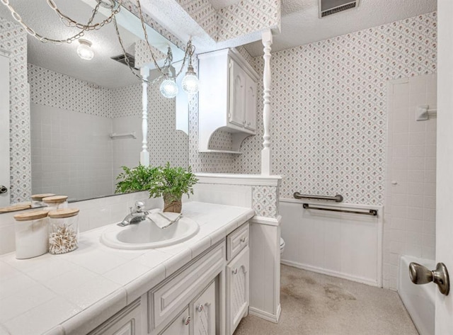 full bathroom with vanity, toilet, a textured ceiling, and shower / washtub combination