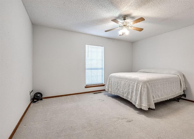 carpeted bedroom featuring ceiling fan and a textured ceiling