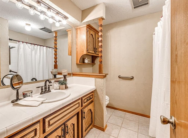 bathroom with vanity, a textured ceiling, and toilet