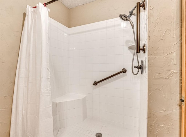 bathroom with a shower with curtain and a textured ceiling