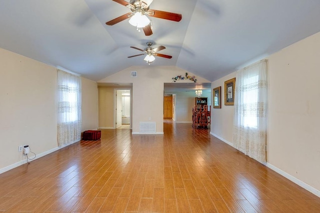 empty room with ceiling fan, vaulted ceiling, and light hardwood / wood-style flooring