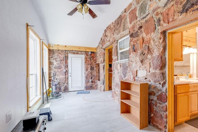 interior space with ceiling fan, tasteful backsplash, sink, and vaulted ceiling