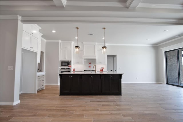 kitchen featuring ornamental molding, stainless steel appliances, a kitchen island with sink, white cabinets, and hanging light fixtures