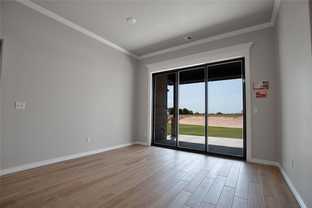 unfurnished room with ornamental molding and light wood-type flooring