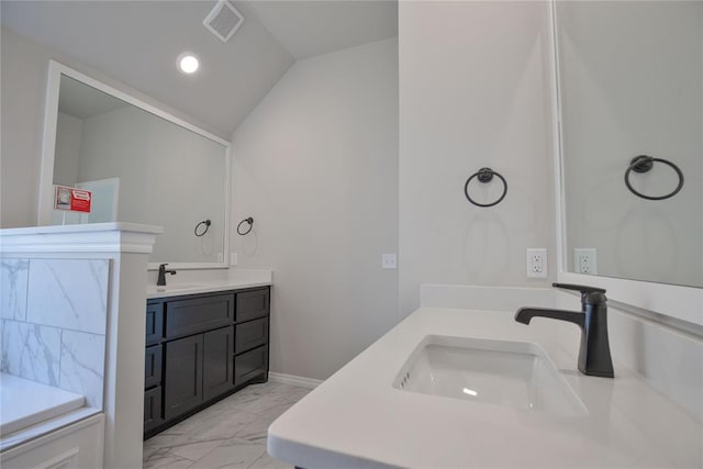 bathroom featuring vanity and lofted ceiling