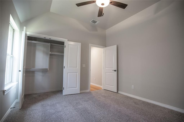 unfurnished bedroom featuring ceiling fan, a closet, multiple windows, and vaulted ceiling