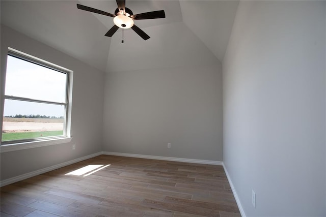 empty room featuring light hardwood / wood-style floors, vaulted ceiling, and ceiling fan