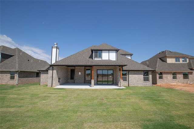 rear view of property featuring a patio area and a lawn