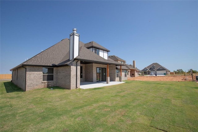 rear view of house featuring a lawn and a patio area