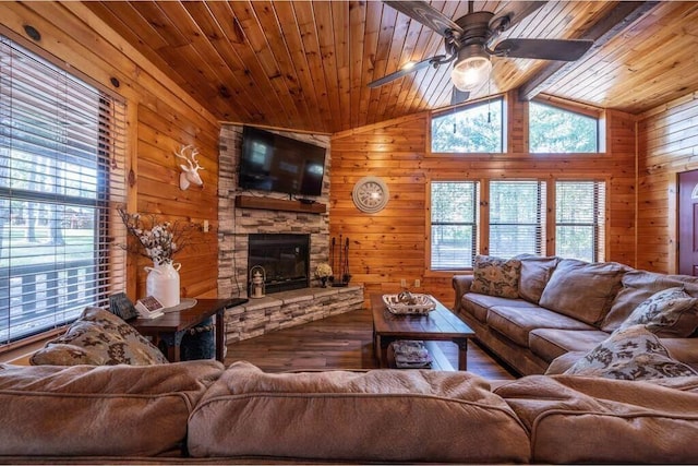 living room with wood walls, ceiling fan, wood-type flooring, and lofted ceiling