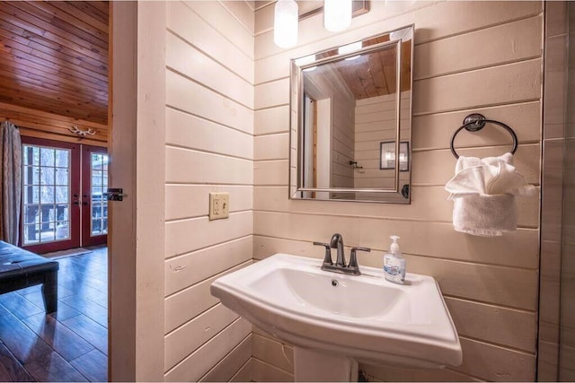 bathroom featuring wood walls, sink, wooden ceiling, and french doors