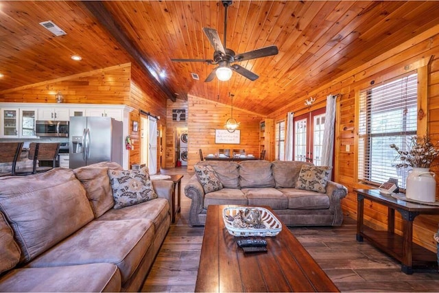 living room with french doors, ceiling fan, wooden walls, dark wood-type flooring, and vaulted ceiling with beams