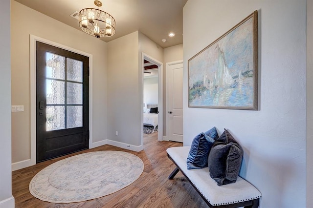 entrance foyer with hardwood / wood-style floors and an inviting chandelier