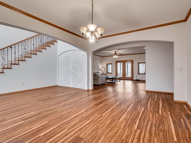 unfurnished living room with hardwood / wood-style flooring, ceiling fan with notable chandelier, and crown molding