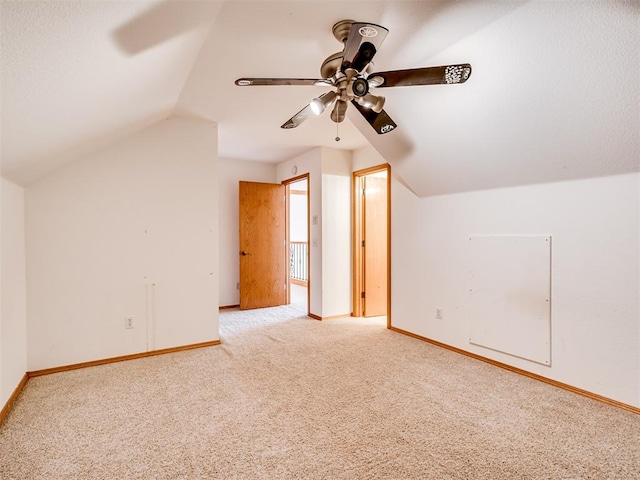 additional living space featuring ceiling fan, light colored carpet, and vaulted ceiling