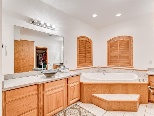 bathroom with tile patterned flooring, vanity, and a tub to relax in